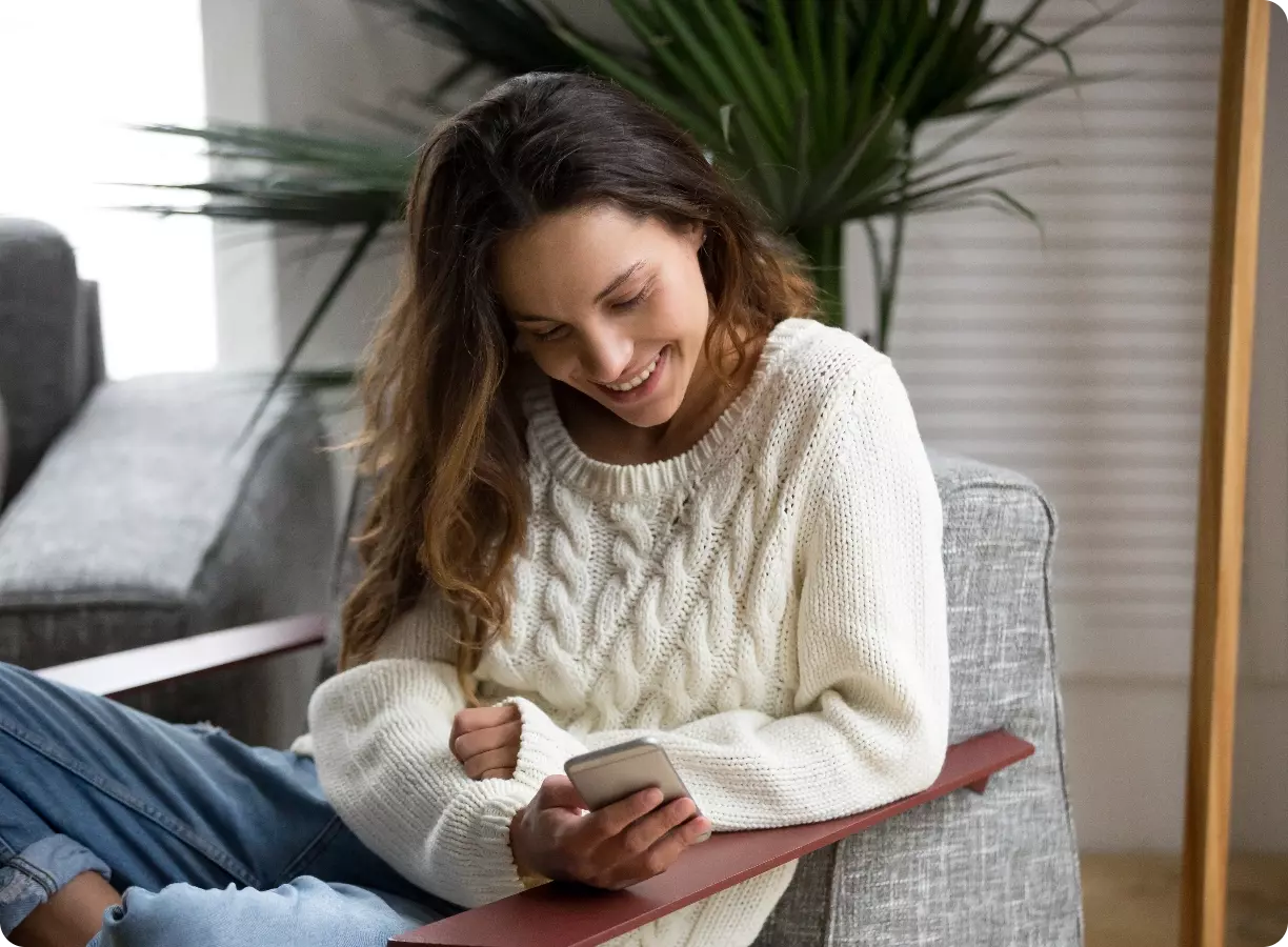 women checking her phone on a chair